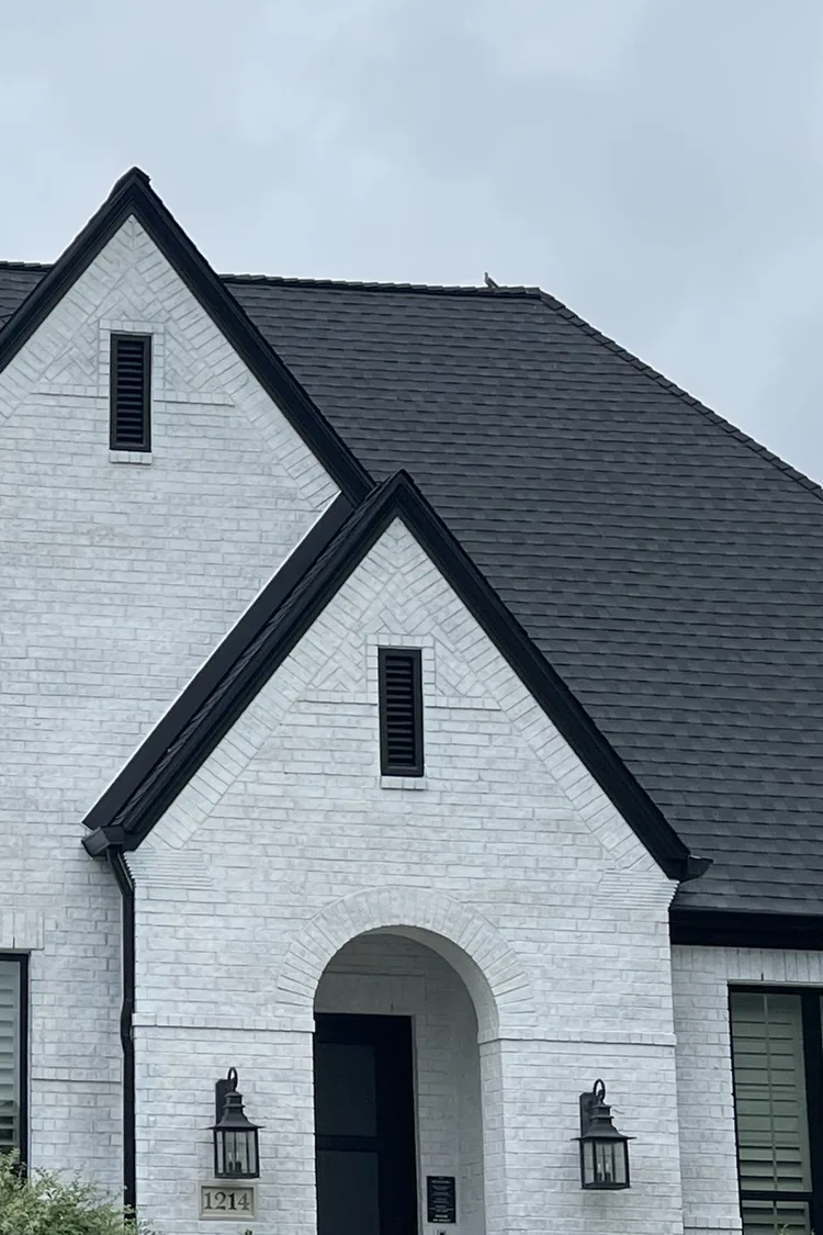 White-painted brick home with black trim by PG Painting